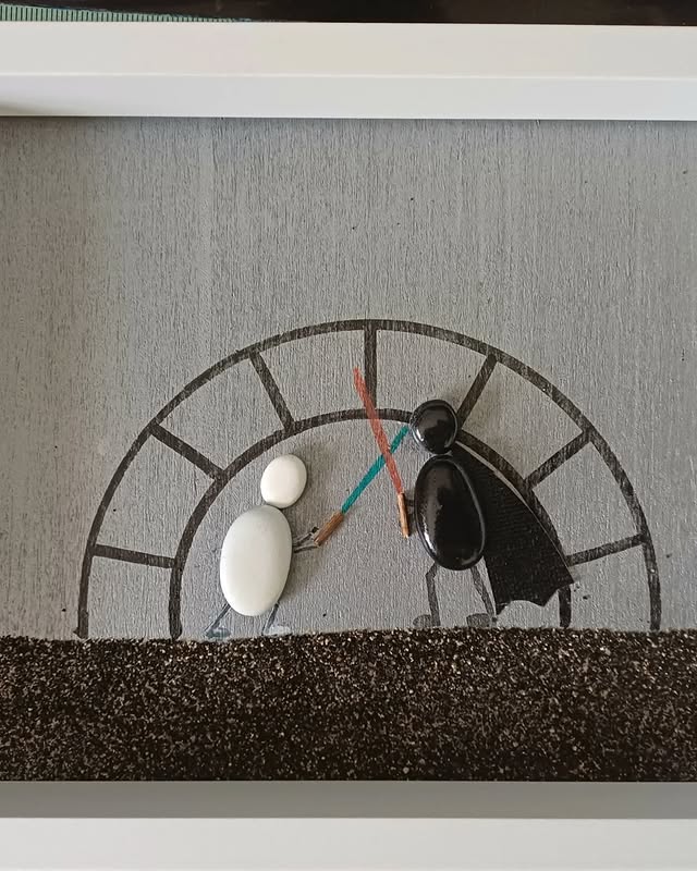 Cuadro con personas luchando hecho con piedras